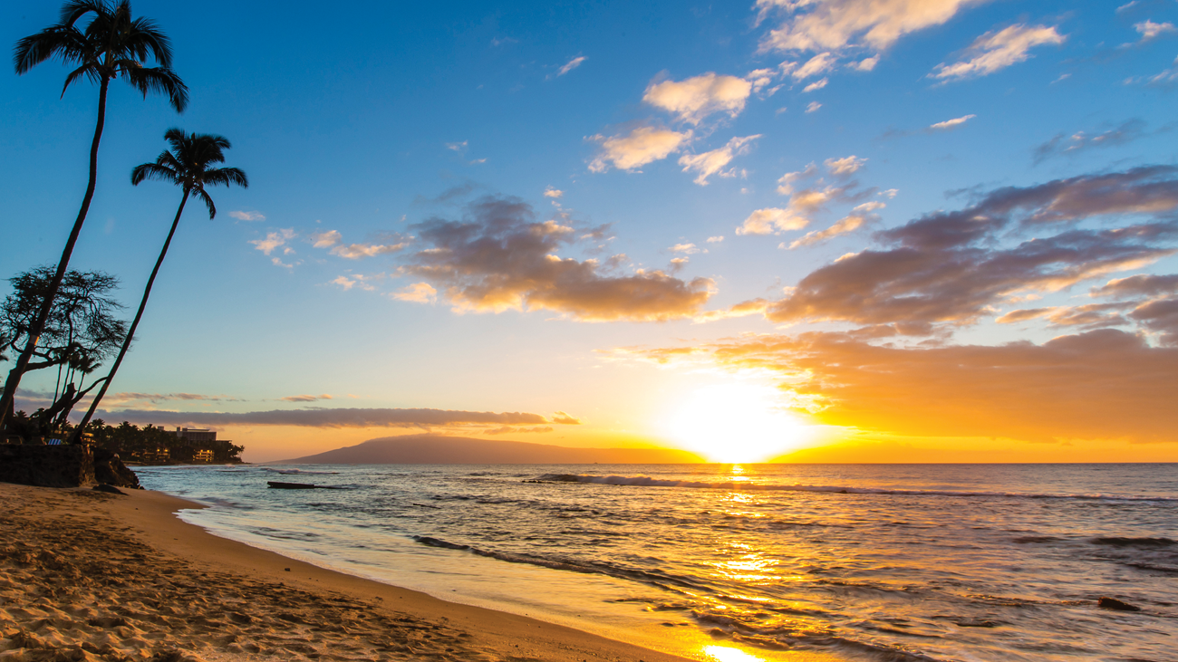 Sunrise over water on a beach in Oʻahu, Hawaiʻi, a Marriott Vacation Club timeshare destination