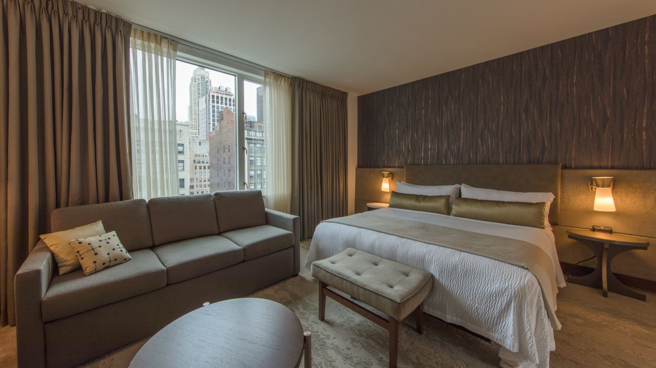 ny-deluxe-king-guestroom-enkg-sitting-area-with-bed-interior-photo