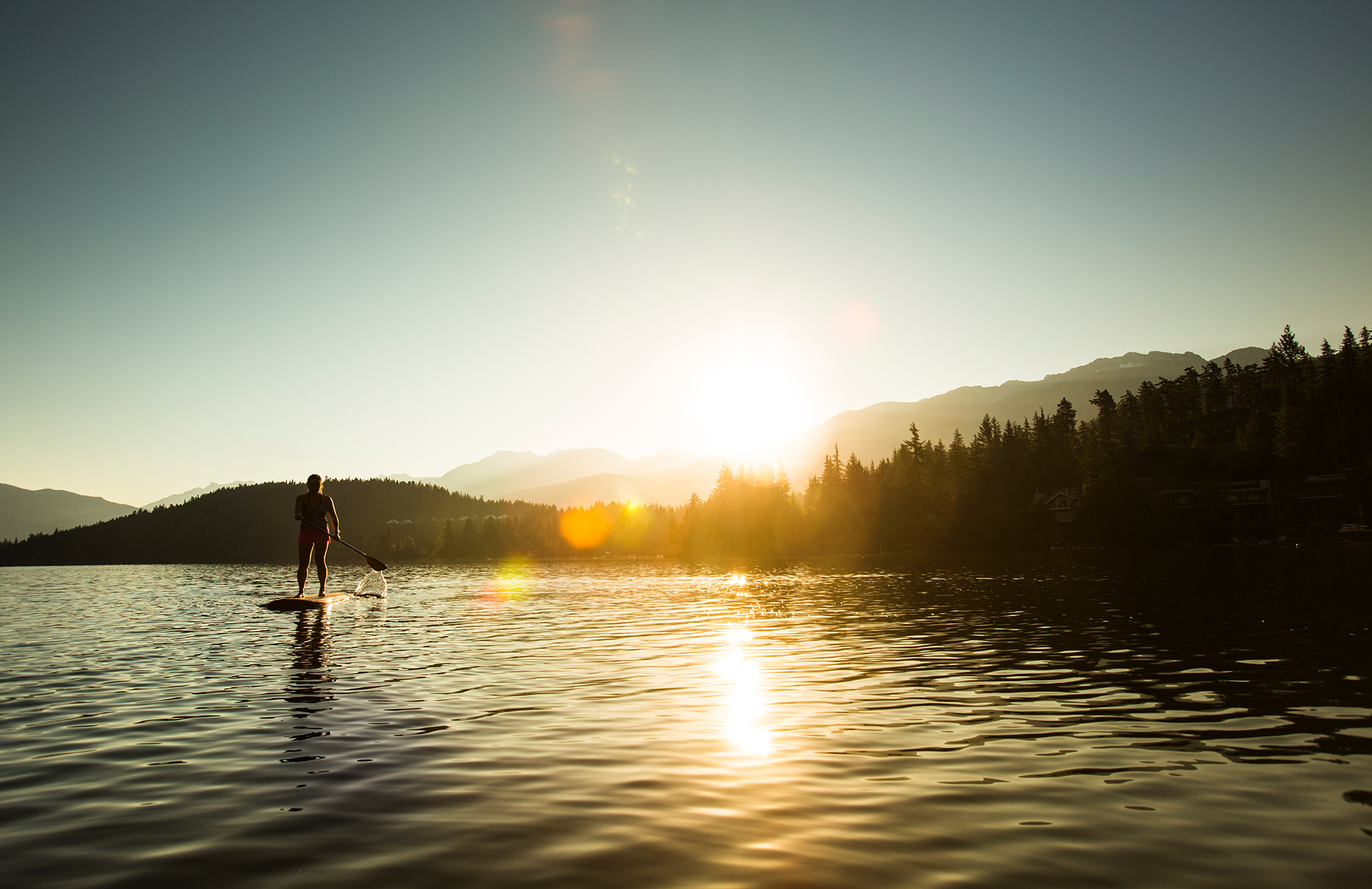 paddleboarder on mountain lake 