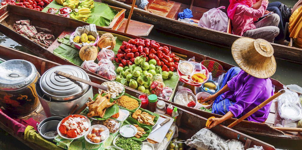 A person sitting in a boat at a floating market in Southeast Asia