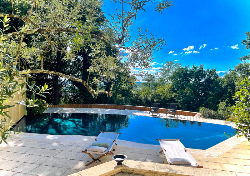 A clear blue pool waits in front of a home
