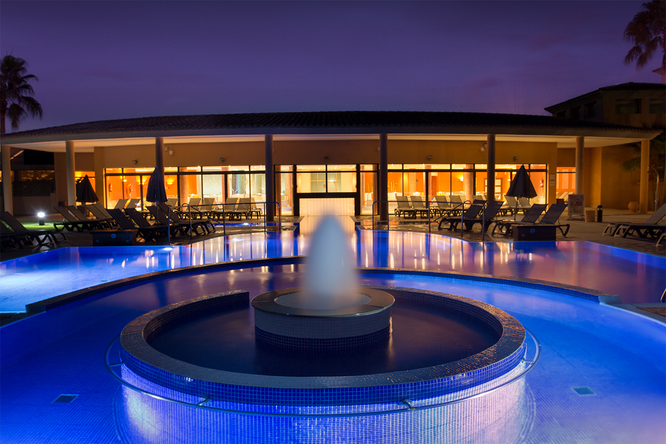 A bubbling fountain is illuminated under the water