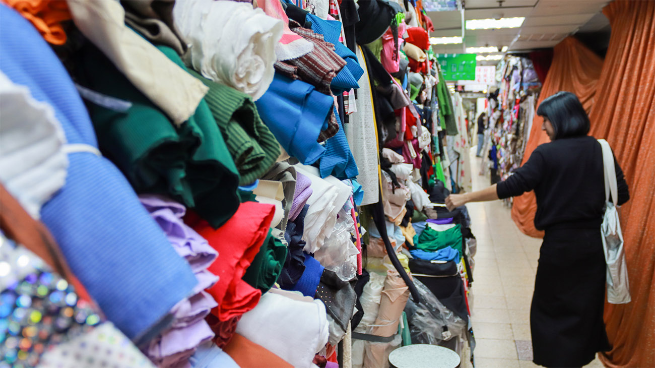 Colorful fabrics are stacked in a store display