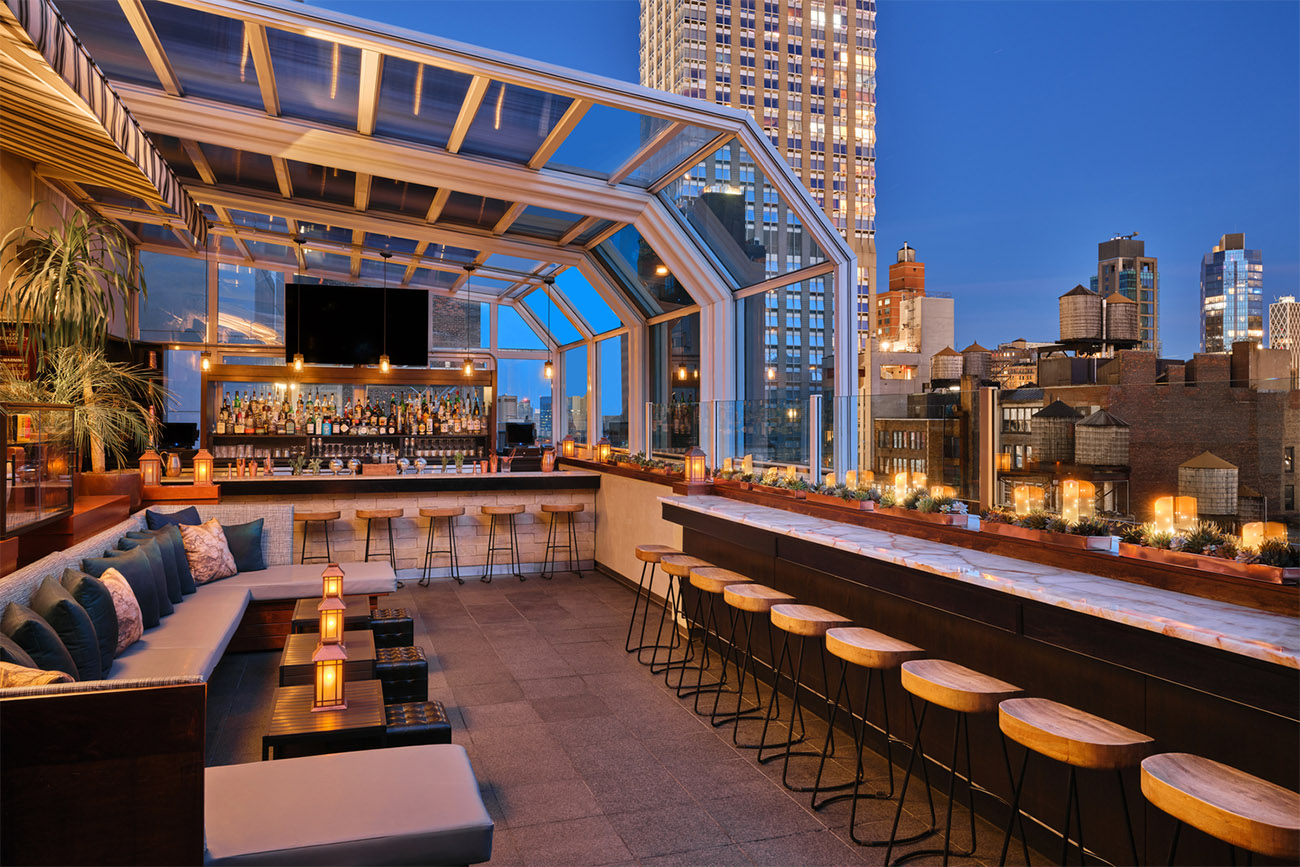 Rooftop patio and bar area and comfortable bench seating in New York City at dusk