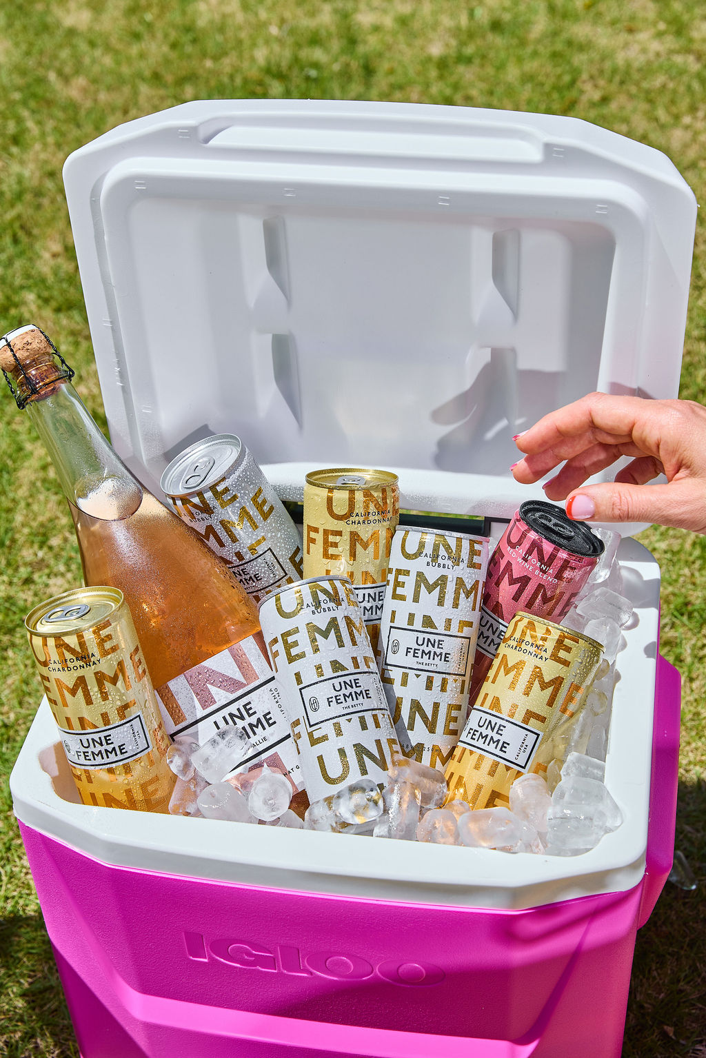 4 A large cooler is stocked with cans and a bottle of Une Femme wine.