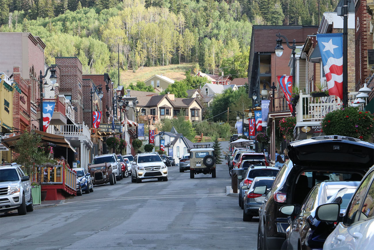 A sun-kissed downtown street is lined with colorful buildings.