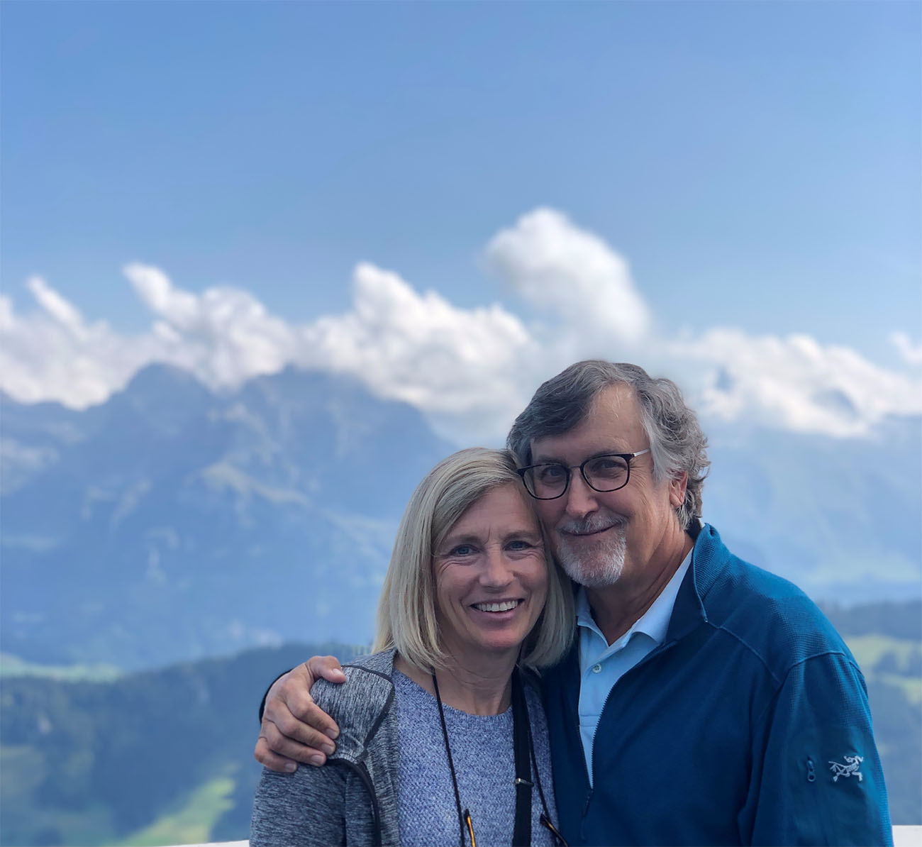 A man and a woman stand in front of a mountain in Switzerland