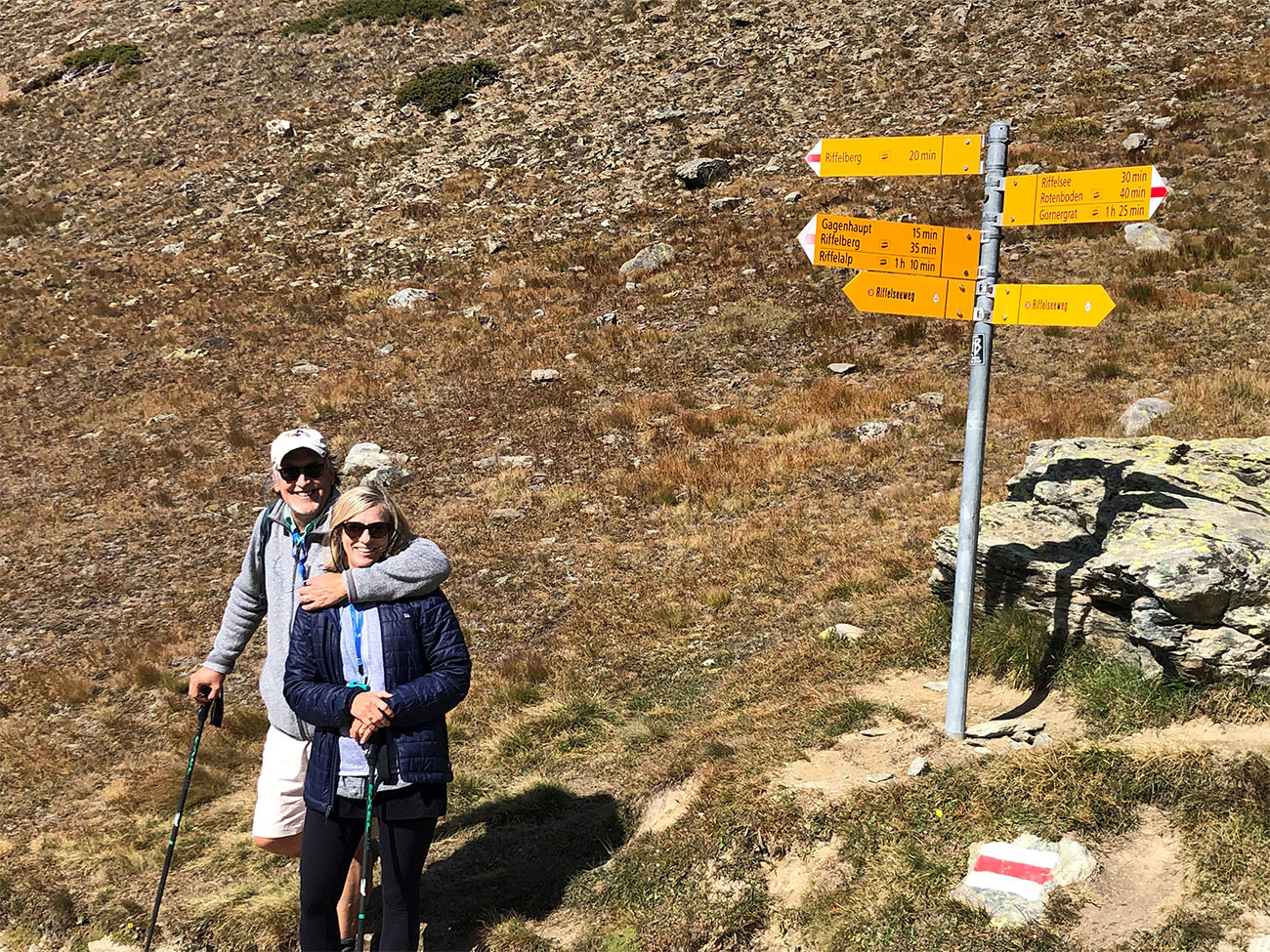 A man and a woman stand with hiking poles