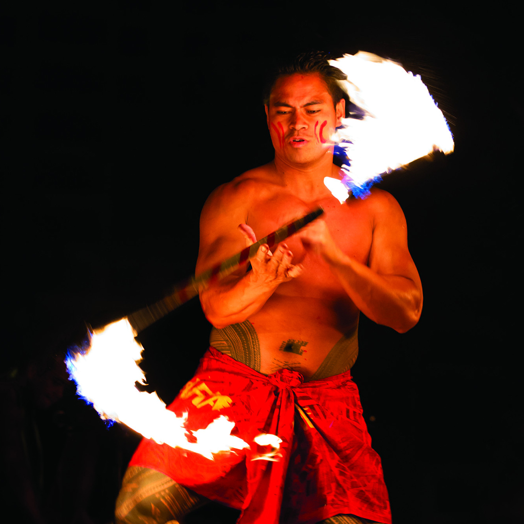 Bright fire illuminates a traditional dancer in Hawaii.