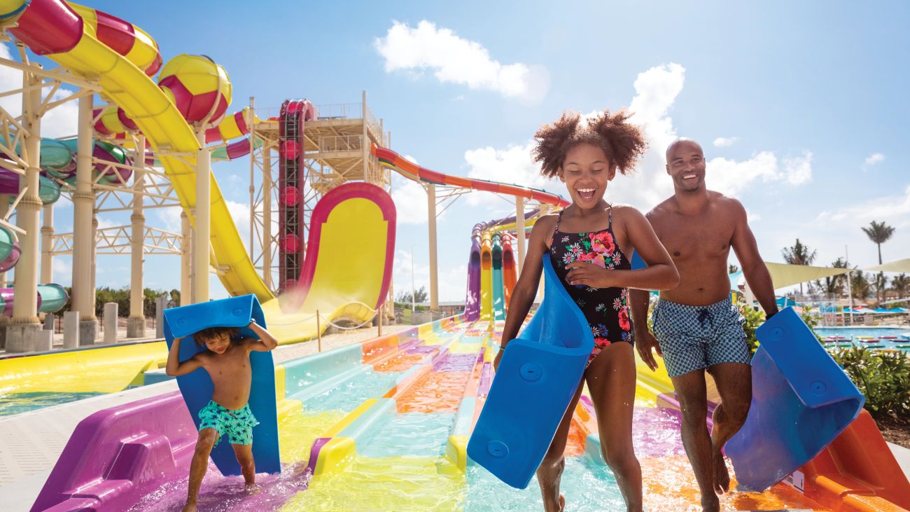 A family enjoys a colorful onboard water park aboard a cruise ship.