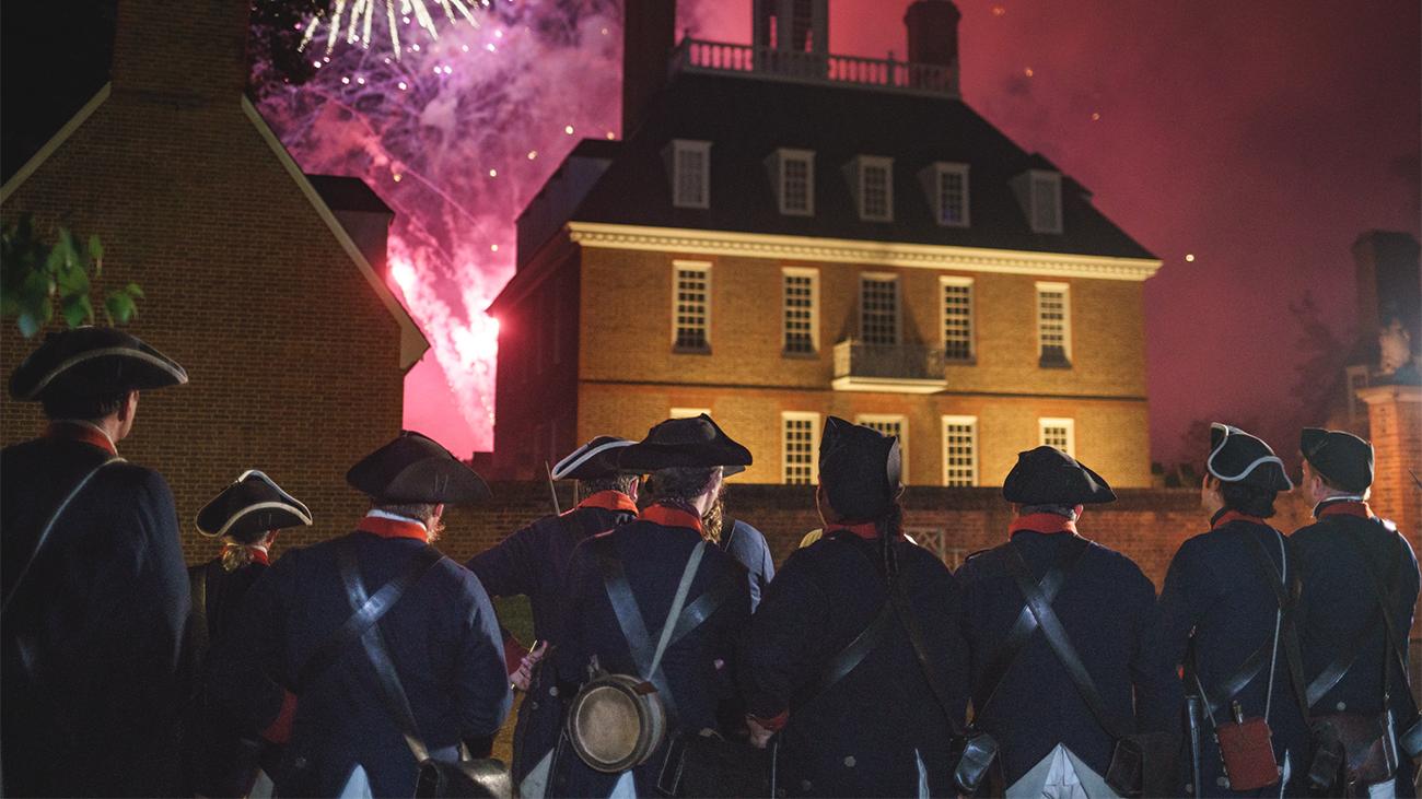 Line of soldiers in colonial-style uniforms watching fireworks in Williamsburg, VA a Marriott Vacation Club destination