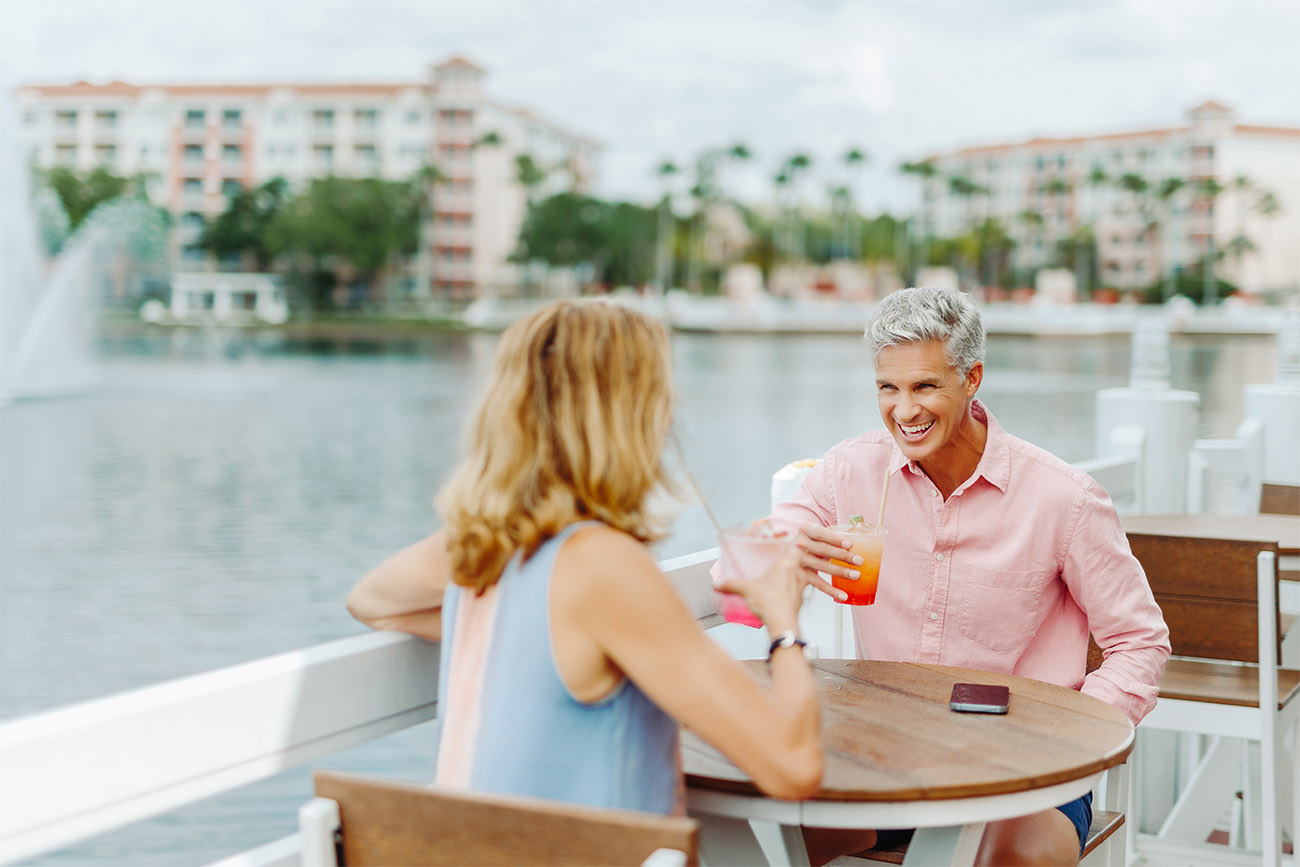 Couple enjoying colorful drinks next to a lake